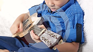 A child plays a broken guitar