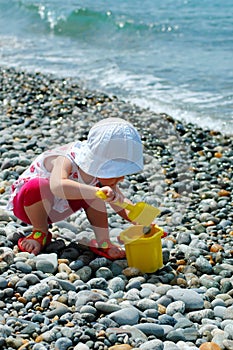 Child plays with a bucket and a shovel