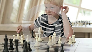 The child plays chess. The boy plays with white pieces