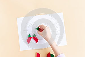 A child plays with colored blocks. A child plays with colored blocks. Wooden shapes Christmas symbols