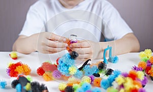 A child plays with colorful mosaic at the table. Quarantine of children at home