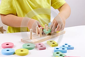 The child plays with colorful toy blocks. eco wooden toys. Little smart child playing natural toys. games for early