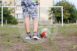 The child plays football on the school soccer field