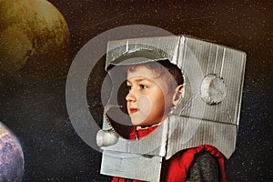 A child plays in a makeshift astronaut helmet out of cardboard