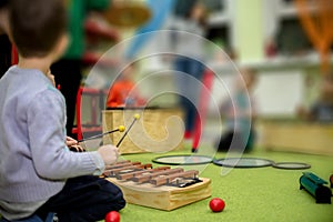 A child plays a musical instrument on Xylophone. Shallow depth of field