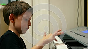 Child plays a piano keyboard. Boy learns to play the synthesizer.Learning and getting used to musical instruments from a young age