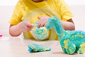 the child plays plasticine from polymer granules at the table,