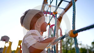 child plays on the playground. concept of a happy childhood and loving family. a child smiles joyfully and climbs a