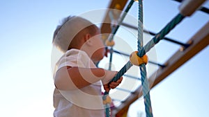 child plays on the playground. concept of a happy childhood and loving family. a child smiles joyfully and climbs a