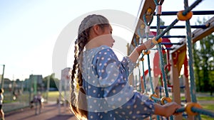 child plays on the playground. concept of a happy childhood and loving family. a child smiles joyfully and climbs a