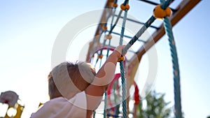 child plays on the playground. concept of a happy childhood and loving family. a child smiles joyfully and climbs a