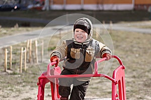 Child plays in the playground in spring