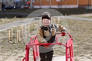 Child plays in the playground in spring