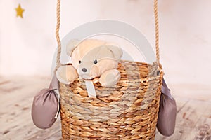 A child plays with a plush bear. Kids toys. Teddy sitting in the balloon basket, aerostat. Retro teddy bear. Toy teddy bear alone