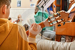 A child plays a six-string guitar at home