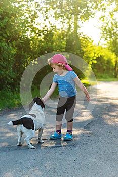 A child plays with a small dog in the park. Selective focus.