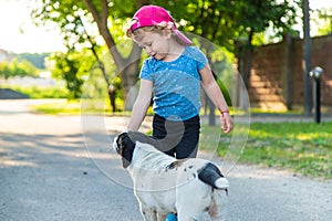 A child plays with a small dog in the park. Selective focus.