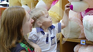 A child plays with a soft toy in the shop