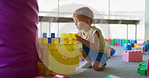 A child plays with toy building blocks in a children's entertainment center