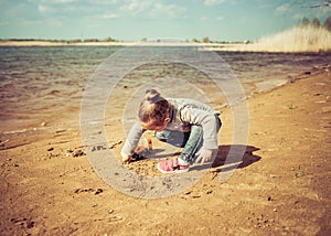 Child plays with toy car truck on the beach