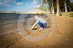 Child plays with toy car truck on the beach