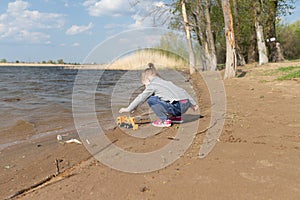 Child plays with toy car truck on the beach