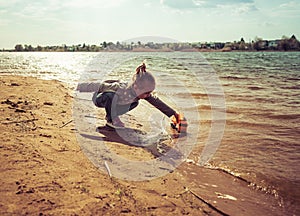 Child plays with toy car truck on the beach