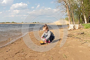 Child plays with toy car truck on the beach