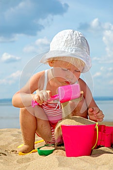 Child plays with toy in sand