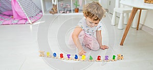 A child plays with a train made of numbers. Selective focus.
