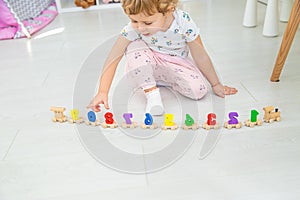 A child plays with a train made of numbers. Selective focus.