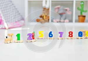 A child plays with a train made of numbers. Selective focus.
