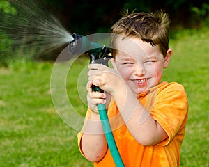 Child plays with water hose outdoors
