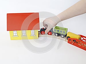 The child plays in a wooden steam locomotive. Wooden railway. Children`s toys. White background. Traps and a steam locomotive. Chi