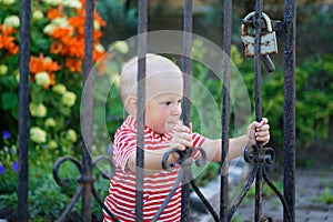 A child plays by a wrought iron grate