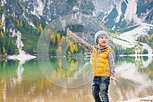 Child pointing on copy space while on lake braies