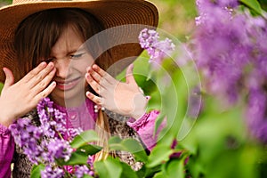 Child with pollen allergy. Girl sneezing and blowing nose because of seasonal allergy. Spring allergy concept. Flowering