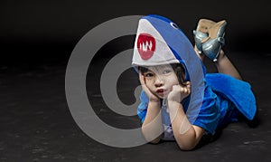 Child portrait with baby shark costume in studio