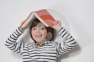 Child portrait with book looking into the camera