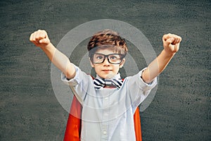 Child portraitCheerful smiling little boy against  chalkboard. Looking at camera. School concept