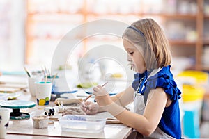 Child at pottery wheel. Kids arts and crafts class