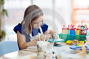 Child at pottery wheel. Kids arts and crafts class