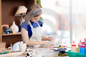 Child at pottery wheel. Kids arts and crafts class