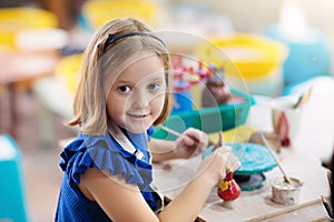 Child at pottery wheel. Kids arts and crafts class