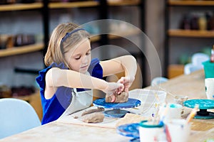 Child at pottery wheel. Kids arts and crafts class