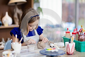 Child at pottery wheel. Kids arts and crafts class