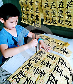 A child practicing Chinese calligraphy carefully