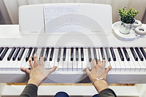 Child practicing on the modern electric piano at home. Music lesson.