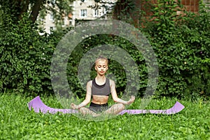 Child practicing yoga in park in day time. Girl is doing yoga in clean and green environment outdoor