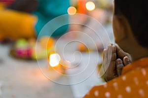 A child praying to hindu god or goddess with folded hands during pushpanjali offerings of puja rituals